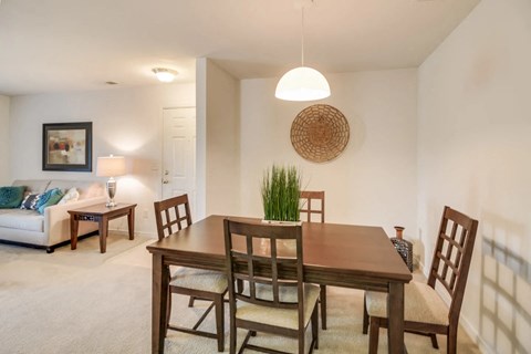 A dining room with a wooden table and chairs.