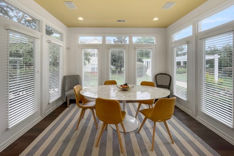 A dining room with a round table and chairs.