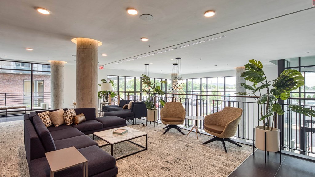 a living room with couches and chairs and a balcony
