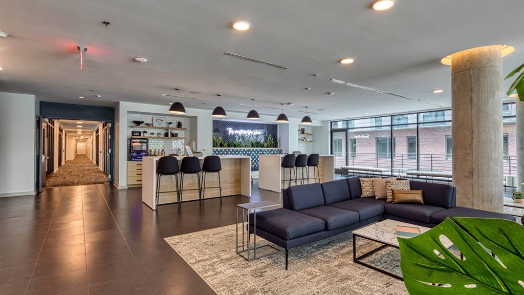 a lounge area with couches and a bar in a lobby