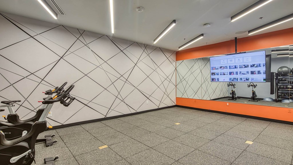 a gym with a treadmill and a projection screen on the wall