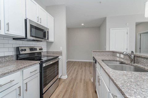 a kitchen with granite counter tops and white cabinets