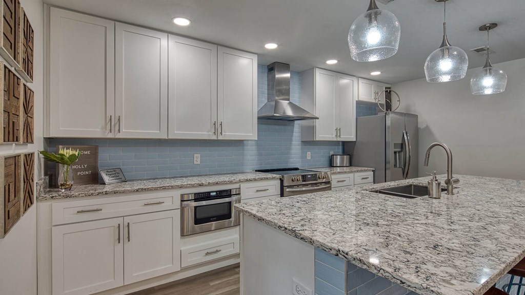 a kitchen with white cabinets and granite counter tops