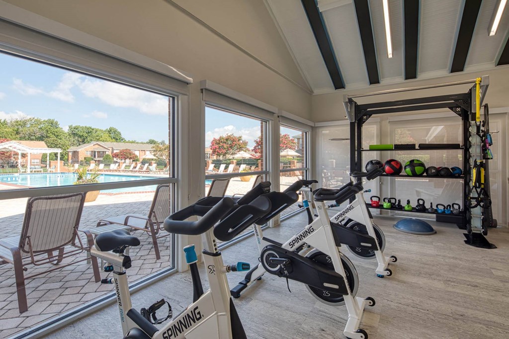 a home gym with a view of a pool and a patio