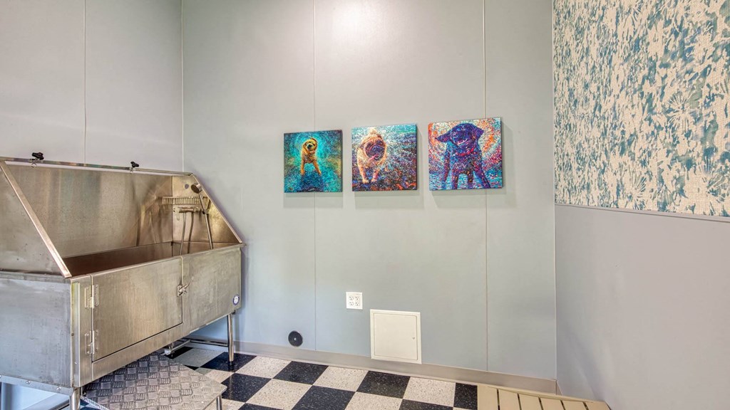 a bathroom with a sink and three paintings on the wall