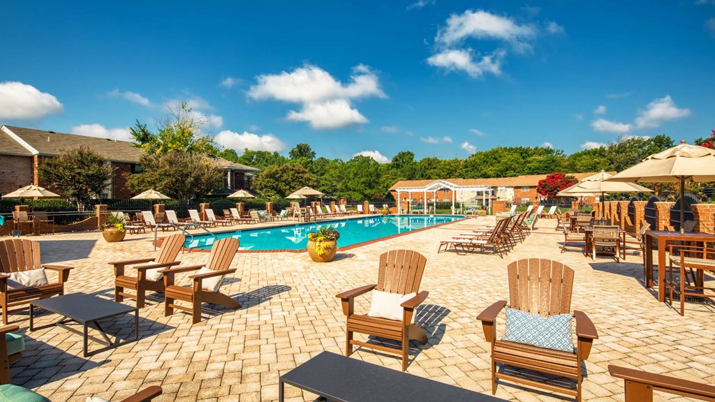 a swimming pool at a resort with chairs and umbrellas