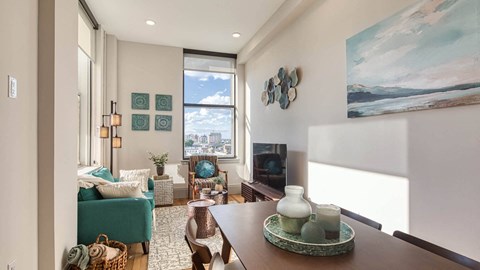 A living room with a green chair and a painting on the wall.