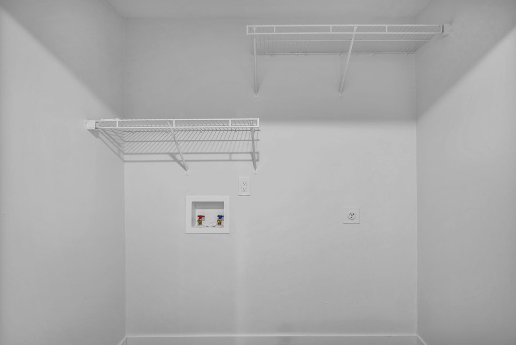 A white room with a shelf and a picture on the wall.