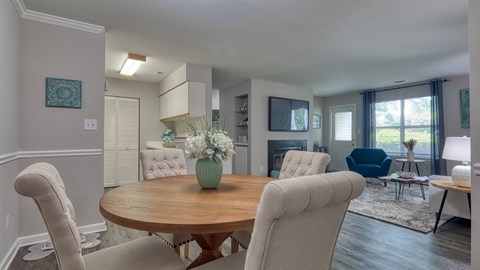 a living room and dining room with a table and chairs