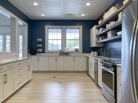 A kitchen with white cabinets and a large refrigerator.