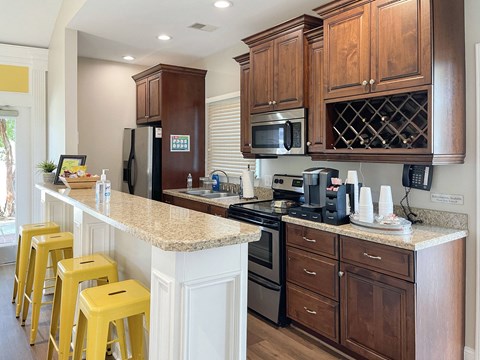 A kitchen with brown cabinets and yellow stools.