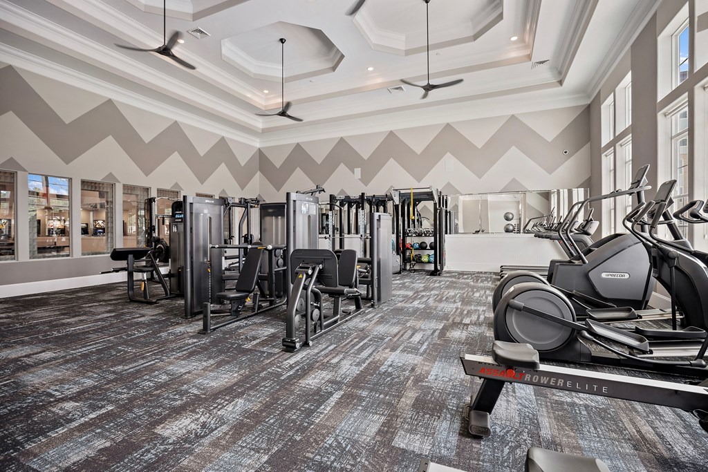 a gym with weights and cardio equipment in a building with large windows at Ellis Station, Durham