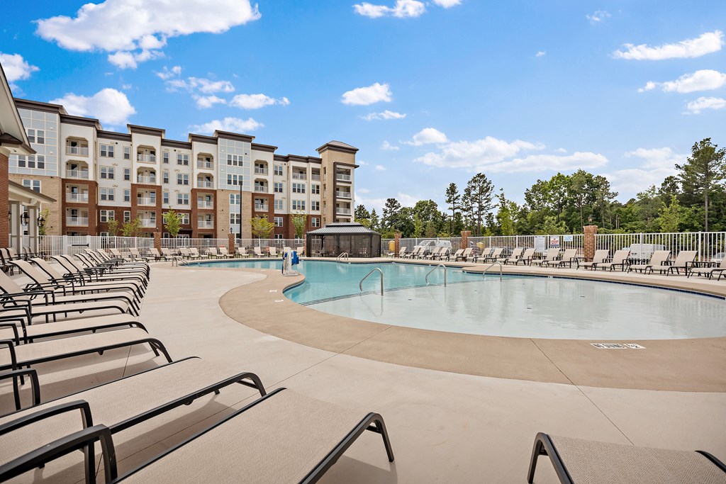 our apartments have a resort style pool with chaise lounge chairs at Ellis Station, Durham, North Carolina