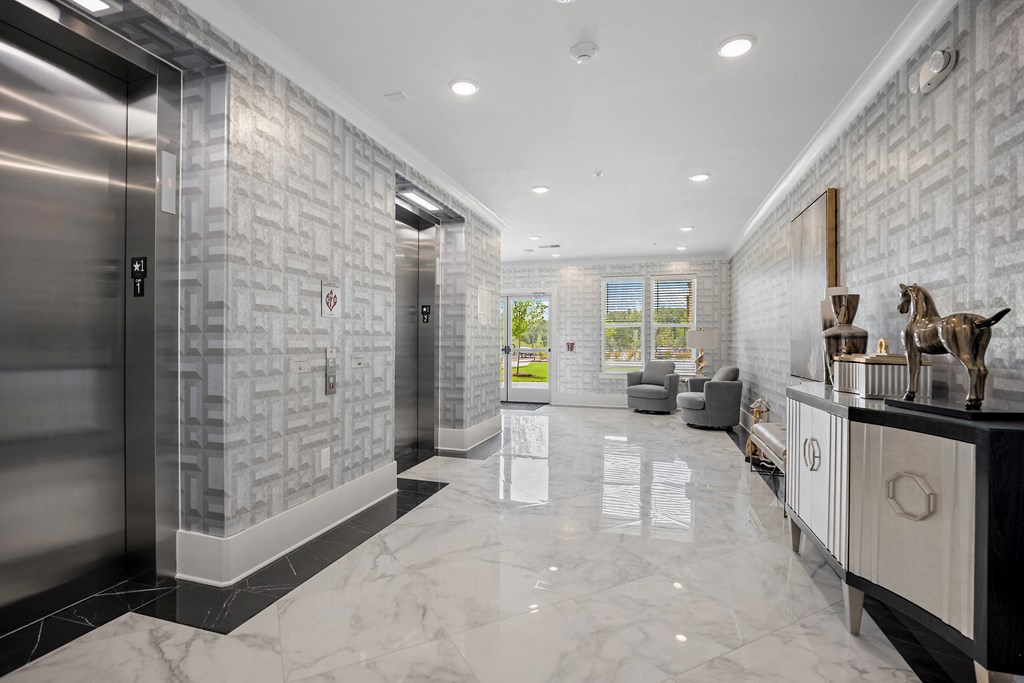 a long hallway with marble floors and tile walls and a glass elevator at Ellis Station, North Carolina