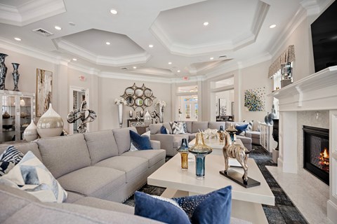 A living room with a grey couch and a fireplace.