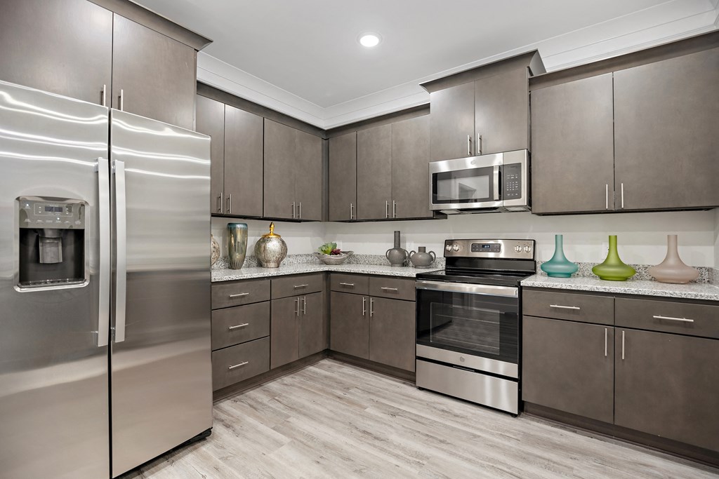 a kitchen with stainless steel appliances and wooden cabinets at Ellis Station, Durham, 27703