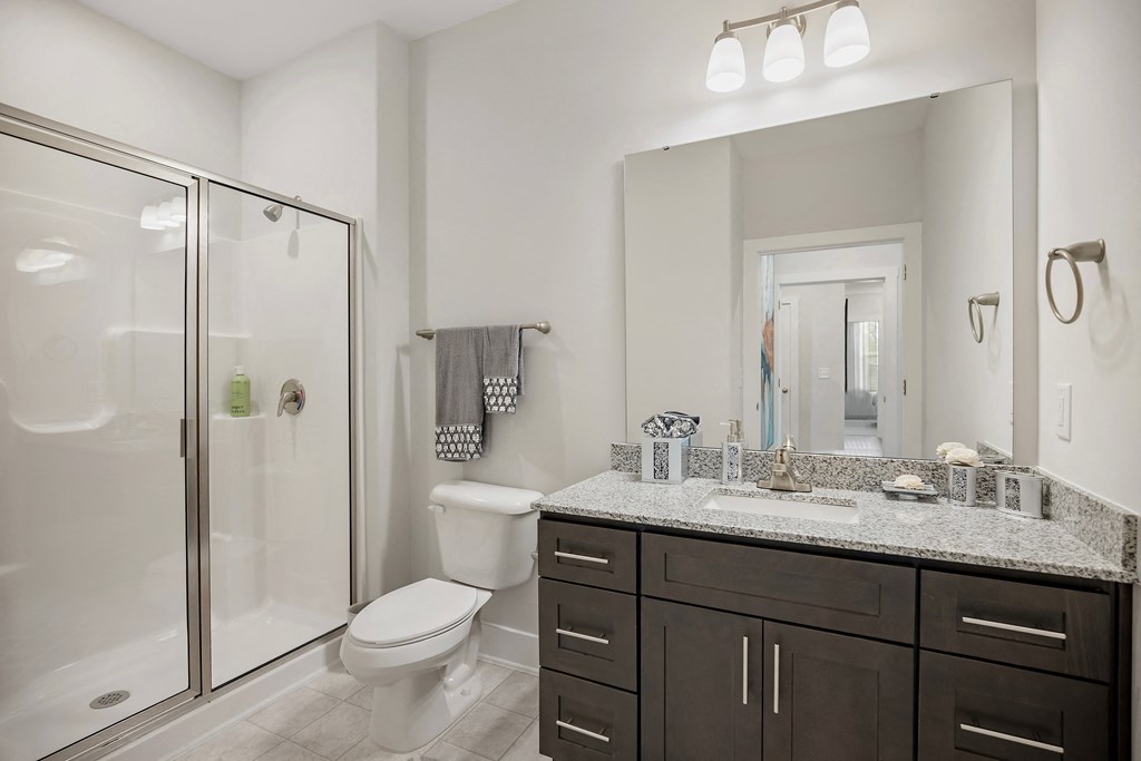 a bathroom with a shower sink and toilet and a mirror at Ellis Station, Durham, North Carolina