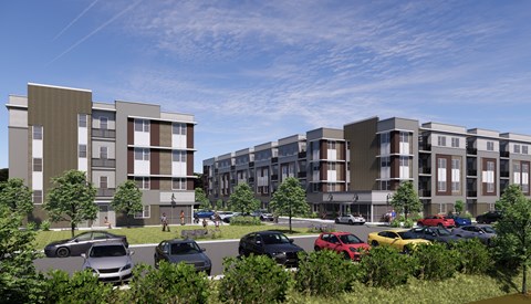 A modern apartment complex with cars parked in front.
