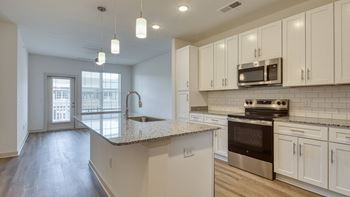 A kitchen with white cabinets and a granite countertop at The Walker Virginia Center, Glen Allen, Virginia 23059