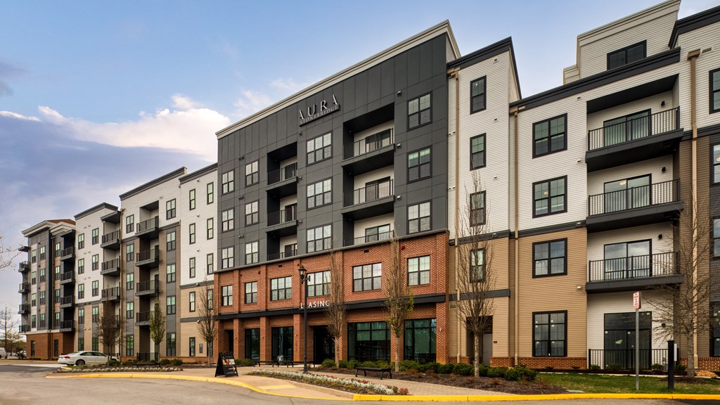an exterior view of an apartment building on a city street at Aura Stonebridge, Richmond, VA