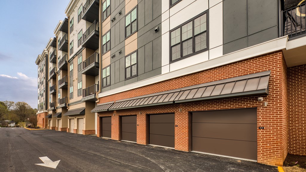 a brick building with brown garage doors on a street at Aura Stonebridge, Virginia