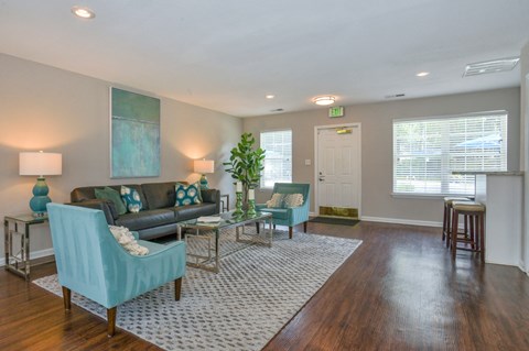 A living room with a blue chair and a grey couch.