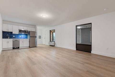 A kitchen with white cabinets and a wooden floor.