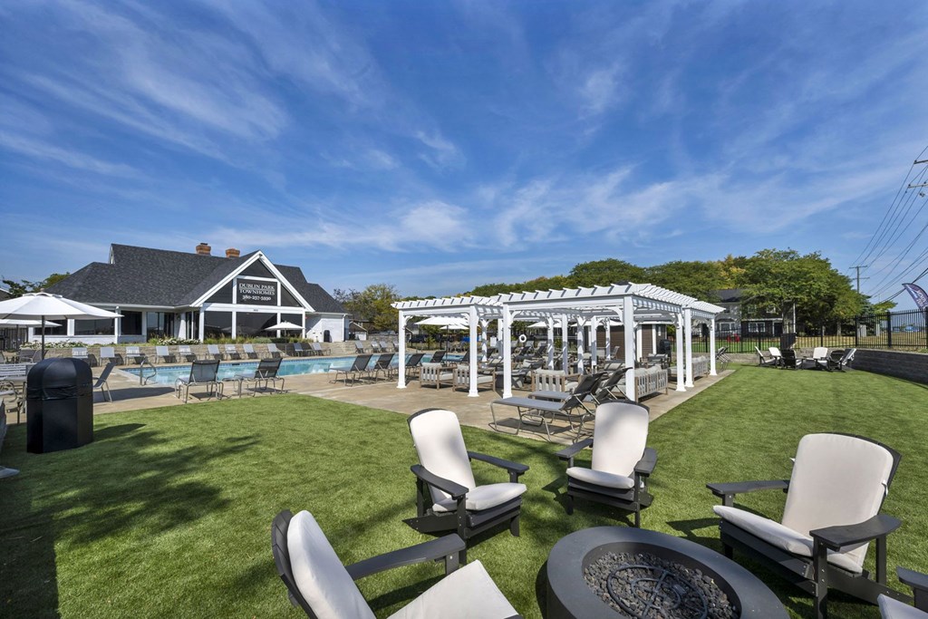 A backyard with a pool and patio furniture.