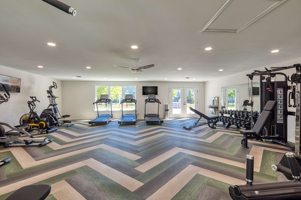 a spacious fitness room with treadmills and other exercise equipment