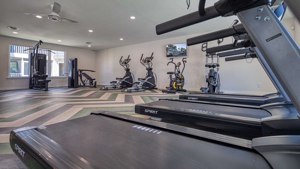 a gym with treadmills and other exercise equipment