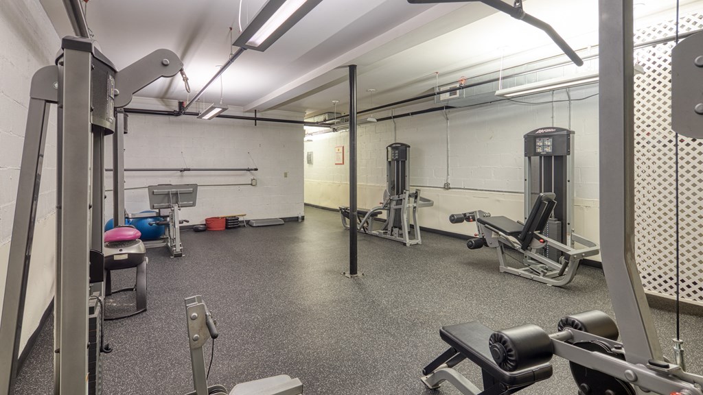 a gym with weights and other equipment in a building with white walls