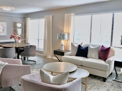 A living room with a white couch and a round table.