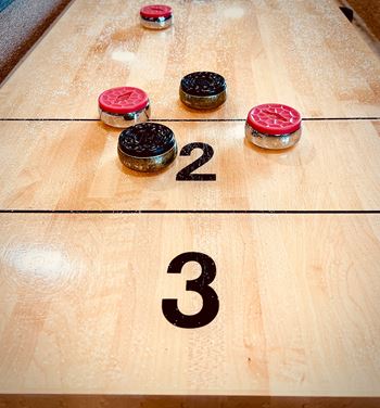 a game of shuffleboard with pins on a wooden table at The Madison, Columbus, Ohio
