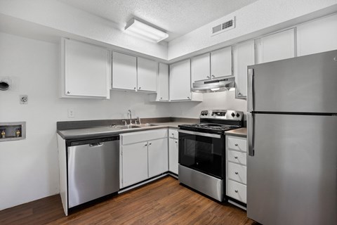 A kitchen with stainless steel appliances and white cabinets.