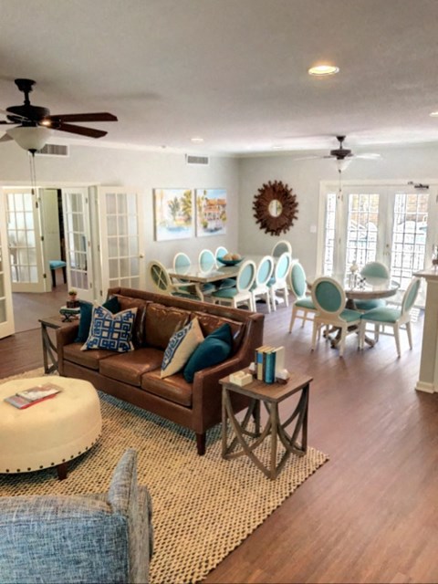 A living room with a brown couch and a round ottoman.