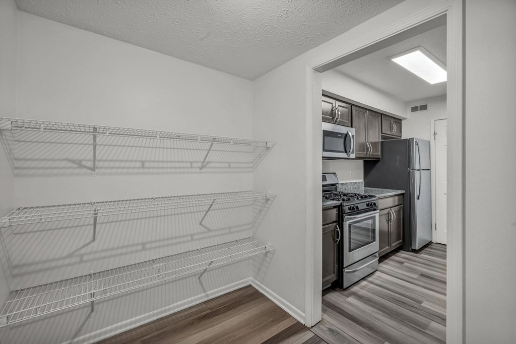 A kitchen with a refrigerator, oven, and microwave.