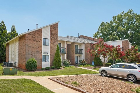 A brick building with a white trim and a car parked in front.