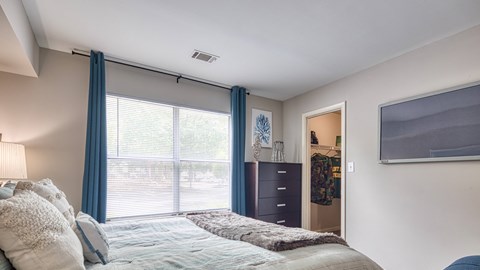a bedroom with a large window and a bed with blue curtains