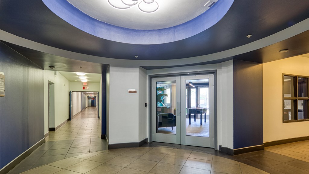 a hallway with doors and a blue ceiling light at Proximity at ODU, Norfolk