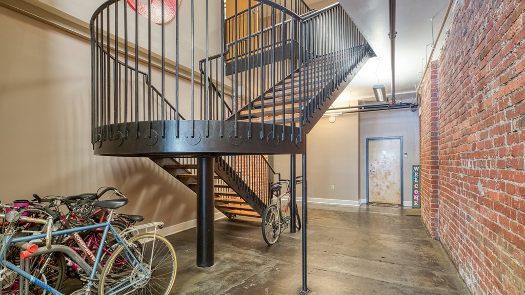 a spiral staircase in a building with bikes parked under it