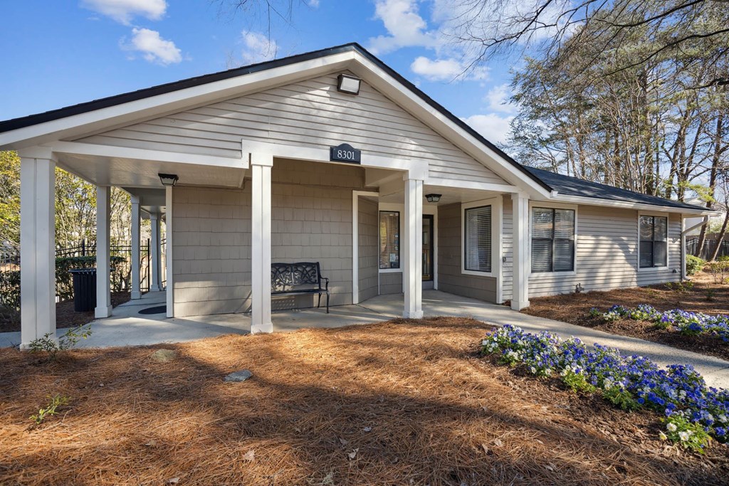 the front of a house with a porch and a bench