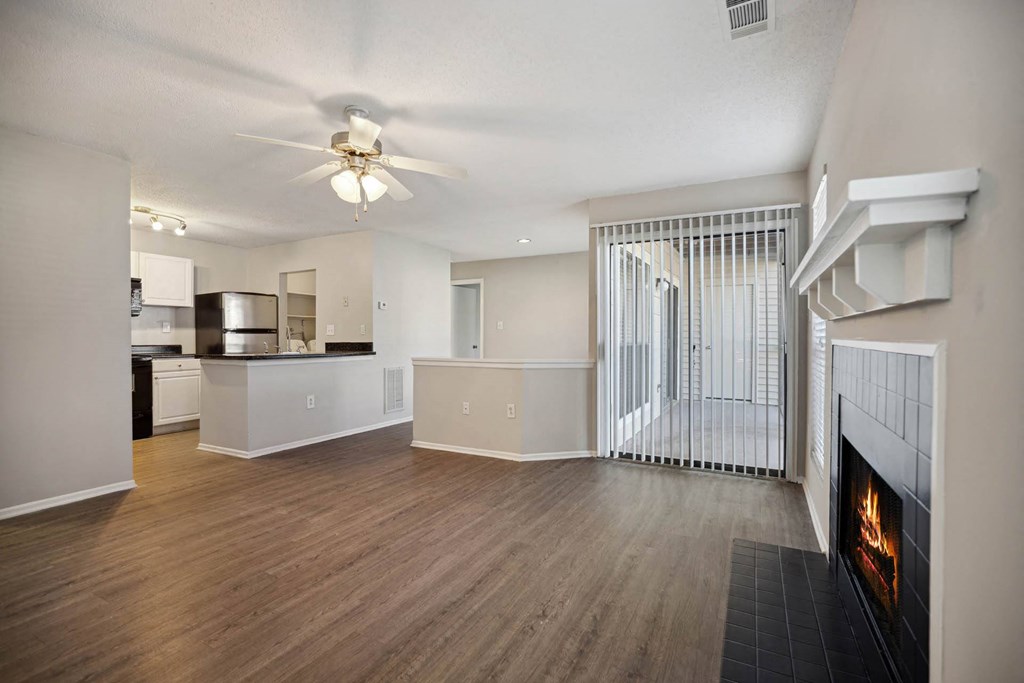 a living room with a fireplace and a kitchen