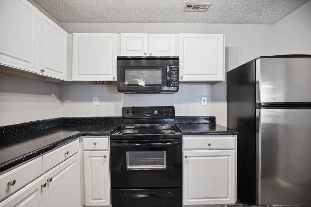 a kitchen with black appliances and white cabinets