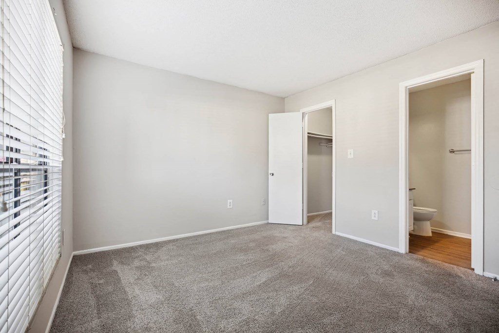 a living room with carpet and a door to a bathroom