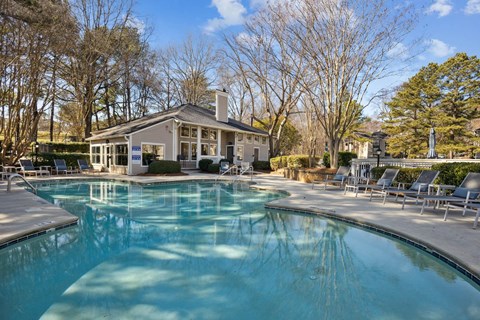 a swimming pool with a house in the background