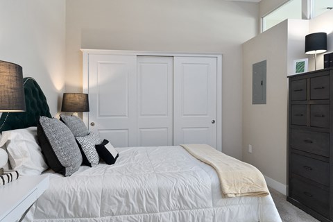 a bedroom with a white bed and white closet doors at Hayden Lofts, Dublin, OH