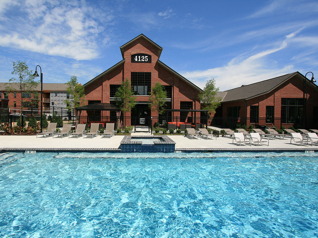 A swimming pool in front of a building with the number 4125 on it.