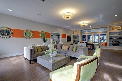 A living room with a grey couch and a green chair.