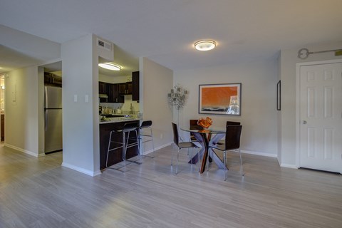 A kitchen with a dining table and chairs.