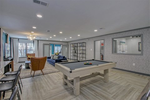 a rec room with a pool table and a living room with chairs